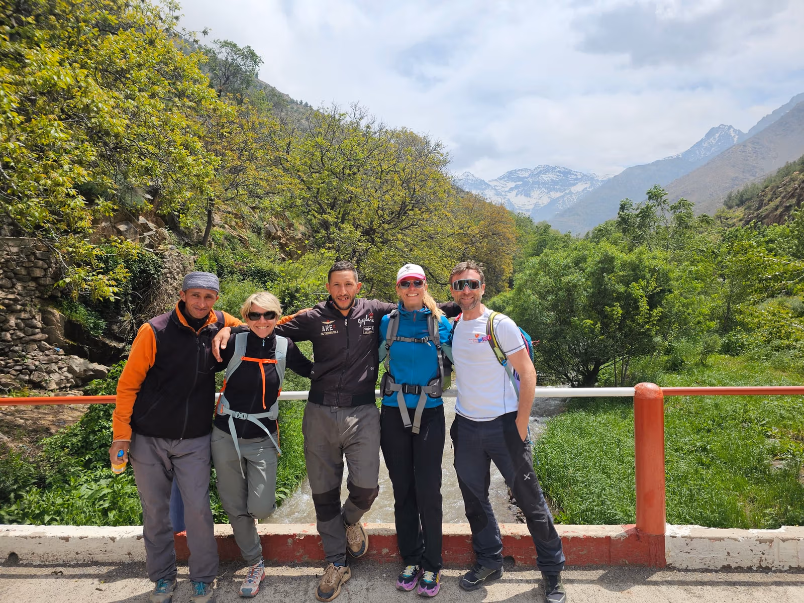 Five trekkers posed on bridge