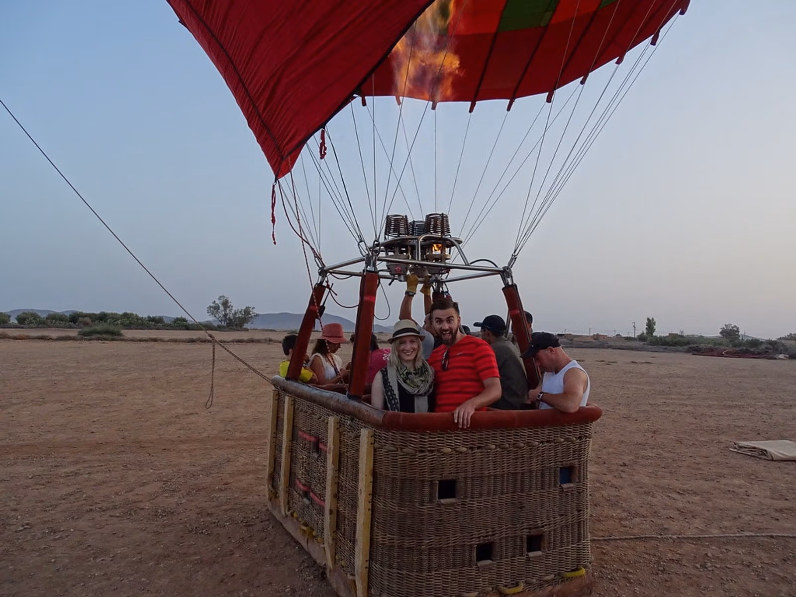 Passengers in a hot-air balloon basket preparing to lift off at dawn near Marrakech
