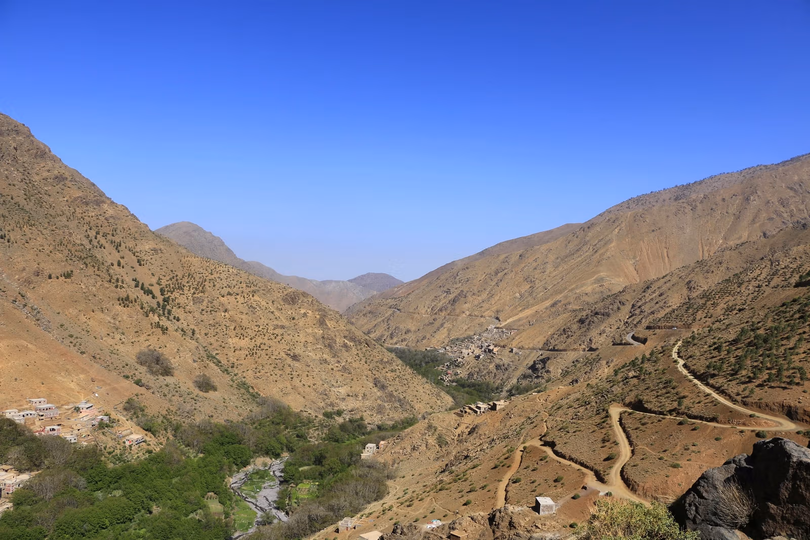 A mountain road winding through an Atlas valley past its villages
